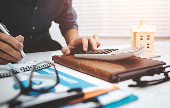 image of papers and reading glasses pencils and a calculator