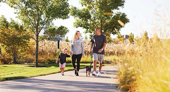 family walking dog on paved trail