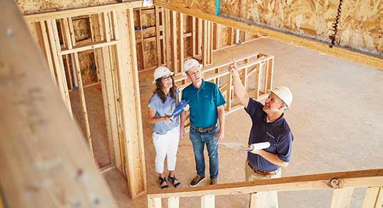 three people wearing hard hats in construction site