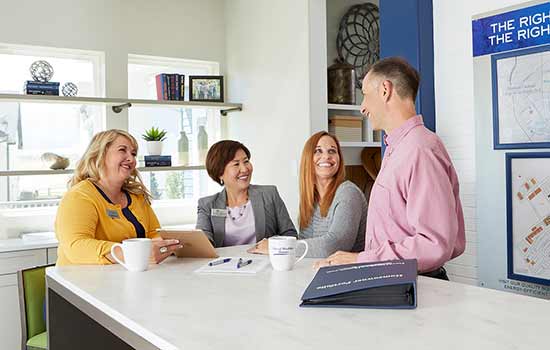 four people sitting a counter and smiling at each other