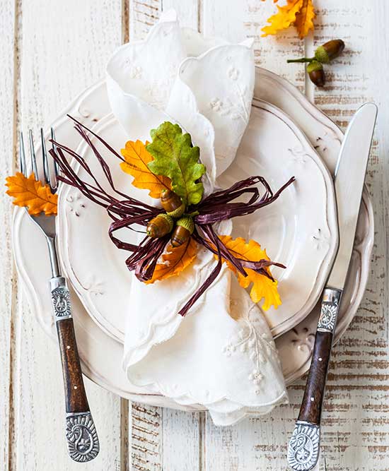 overview of place setting with a folded napkins and leaves