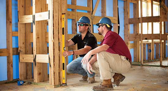 two builders wearing construction hats in construction site