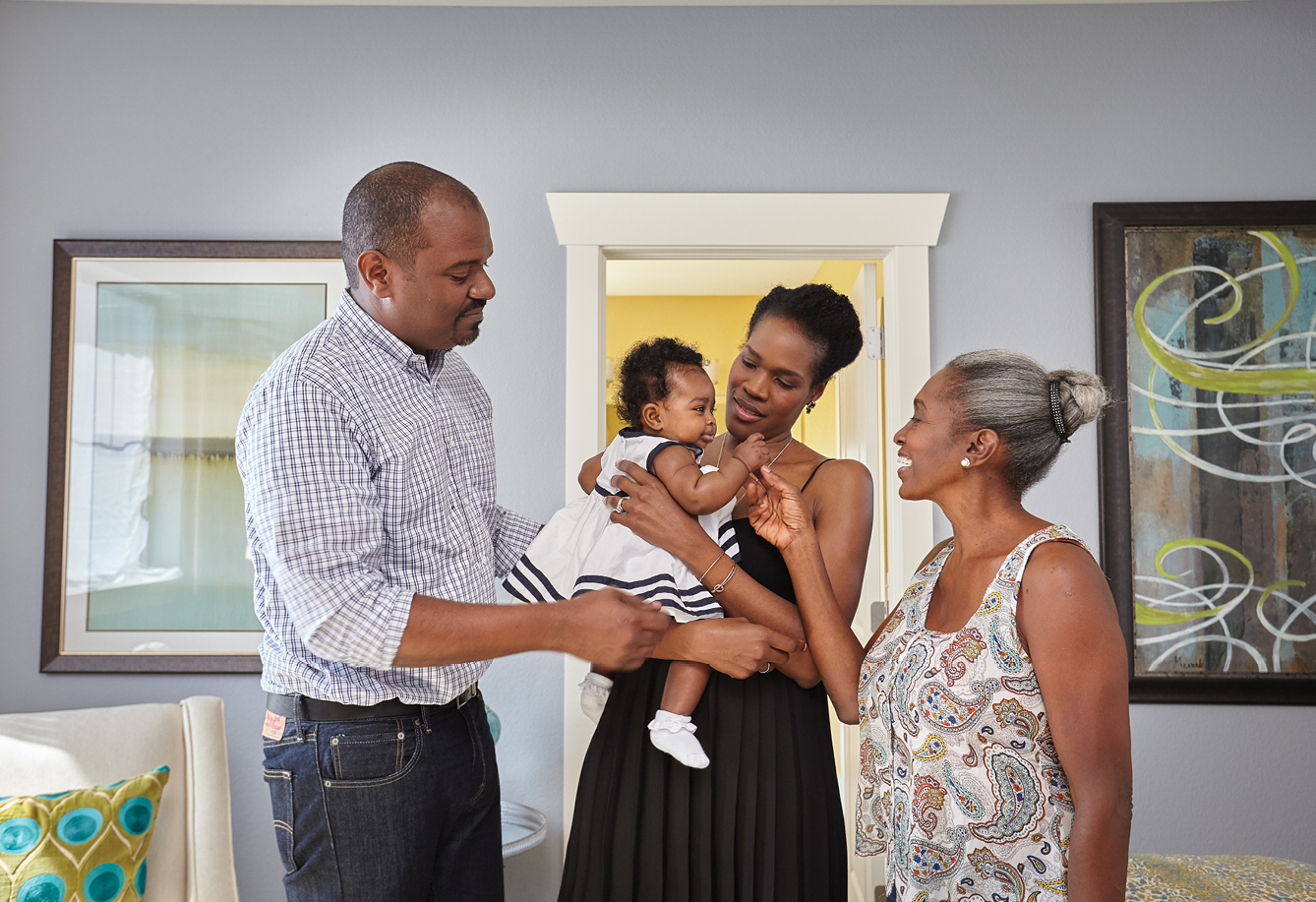 Three generations of a family enjoying one another’s company inside of a beautiful David Weekley Home.