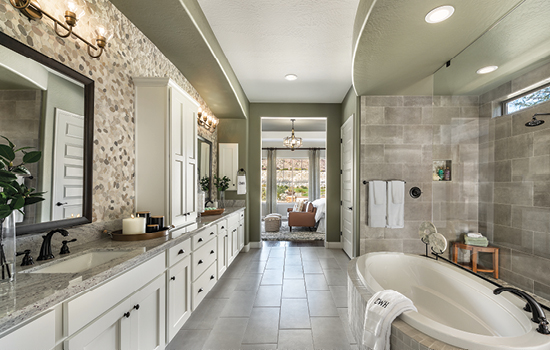 This Owner’s Bath in The Fruition Model Home in Phoenix is decorated with candles and potted plants.