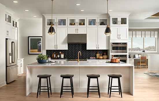 A beautiful David Weekley model home’s kitchen with a few decorative bottles and trendy cookware decorating the otherwise pristine countertops.