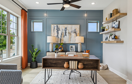 A well-lit study with an accent wall in a David Weekley model home in McKinney, TX.