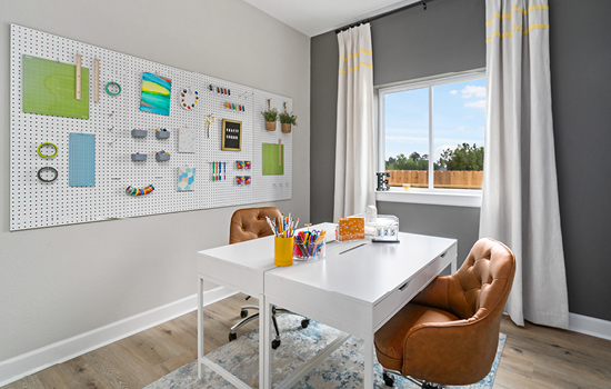 An organized craft room with an accent wall in a David Weekley model home in Tomball, TX.