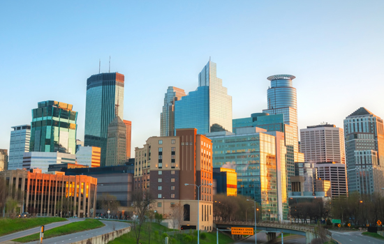 Sunlight is shining on the windows of Downtown Minneapolis office buildings, a sight that people who move to Minneapolis will become more familiar with