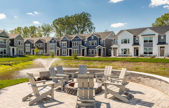 A Community Firepit Overlooking a Fountain with beautiful David Weekley Homes in the background, much like the one you can move into when you buy a new home in Burnsville, MN