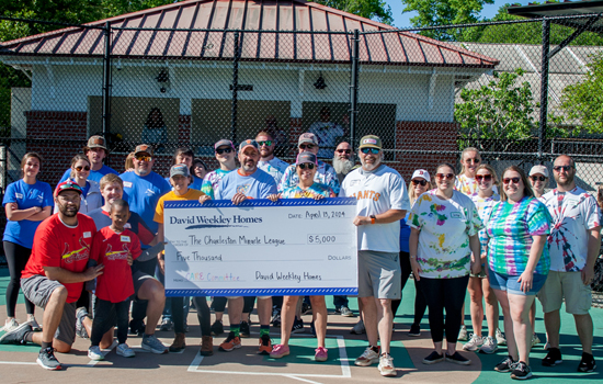 David Weekley Homes Team Members posing with a large donation check
