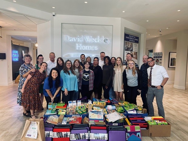 David Weekley Homes Team Members posing with collected school supplies