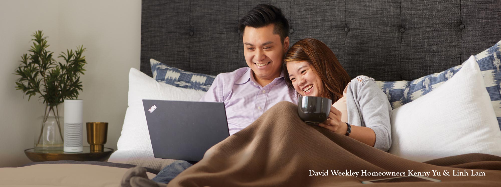 couple in bed looking at laptop