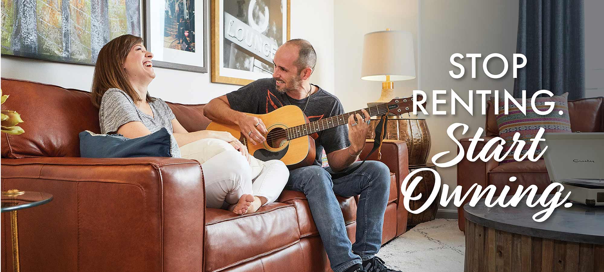 couple playing guitar on a couch